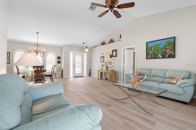 living room with ceiling fan with notable chandelier, light hardwood / wood-style flooring, and vaulted ceiling