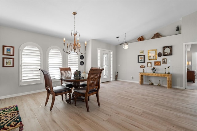 dining area with light hardwood / wood-style floors, lofted ceiling, and a notable chandelier