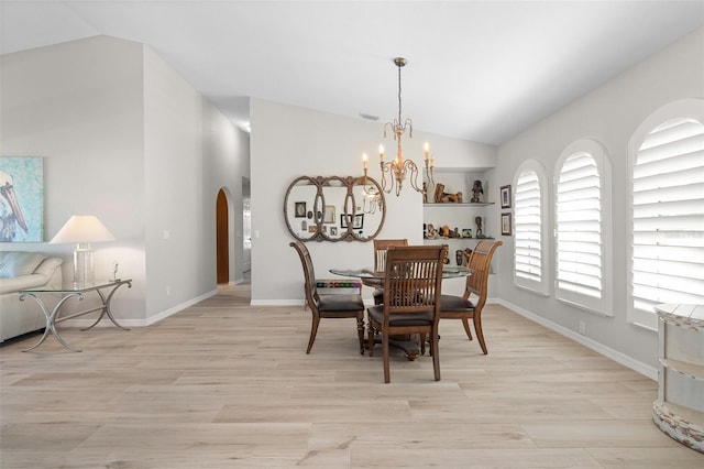 dining area featuring lofted ceiling, light hardwood / wood-style flooring, and a chandelier