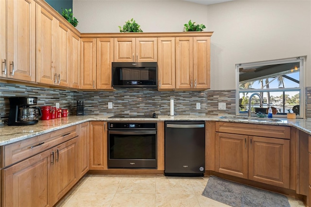 kitchen with tasteful backsplash, light stone counters, sink, and black appliances