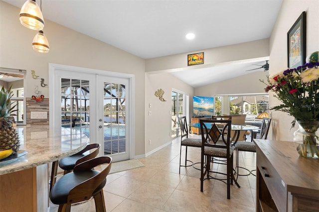 tiled dining room featuring ceiling fan, french doors, and vaulted ceiling