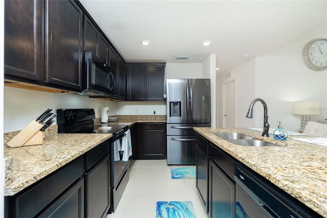 kitchen featuring light stone countertops, sink, light tile patterned flooring, and black appliances