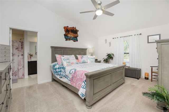 bedroom with light carpet, ceiling fan, ensuite bathroom, and vaulted ceiling