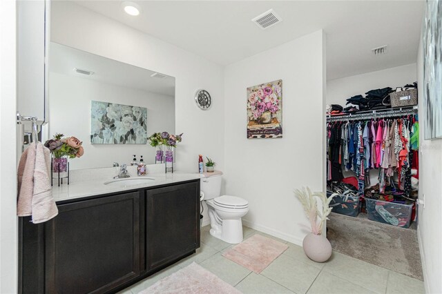 bathroom featuring tile patterned flooring, vanity, and toilet