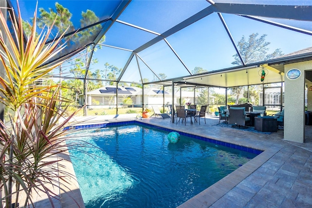 view of pool with glass enclosure and a patio