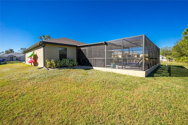 rear view of property with a yard and glass enclosure