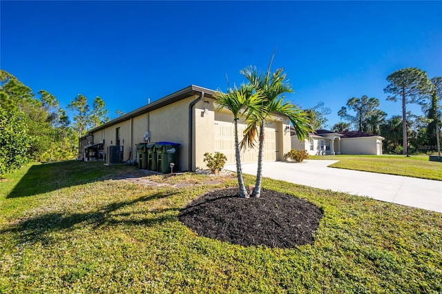 view of home's exterior featuring a lawn, central AC unit, and a garage