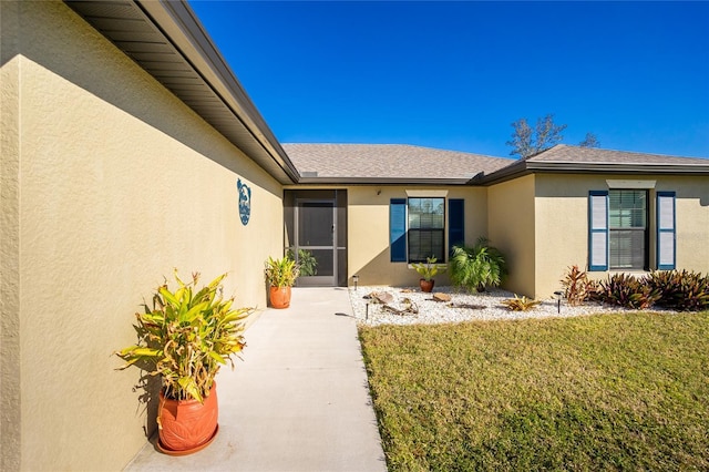 property entrance featuring a lawn