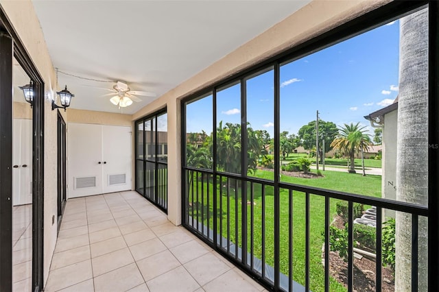 unfurnished sunroom with ceiling fan