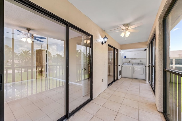 unfurnished sunroom featuring ceiling fan and washer and dryer