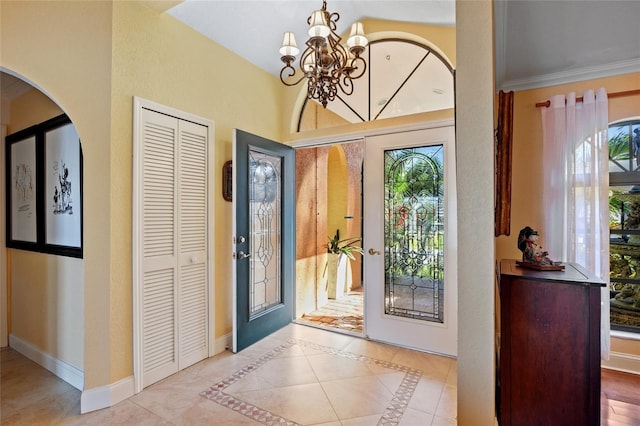 tiled foyer featuring an inviting chandelier