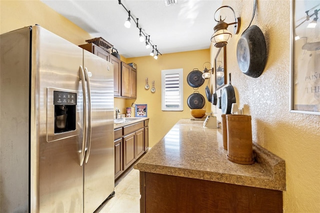 kitchen with rail lighting, stainless steel fridge with ice dispenser, sink, and light tile patterned floors