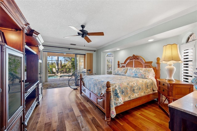 bedroom with access to exterior, ceiling fan, dark wood-type flooring, a textured ceiling, and ornamental molding