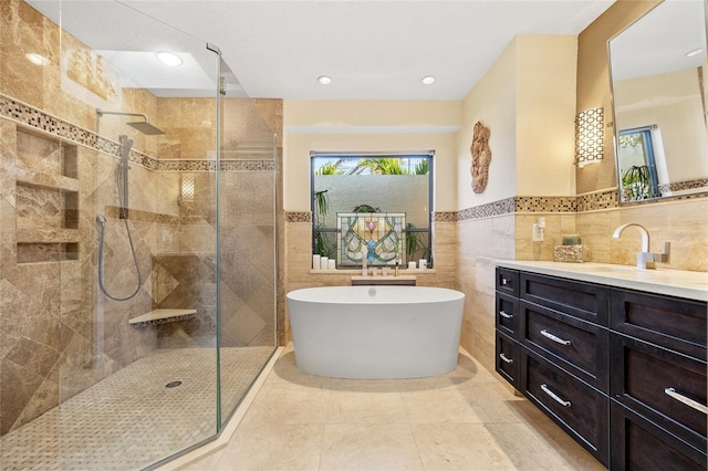 bathroom featuring tile patterned floors, vanity, independent shower and bath, and tile walls