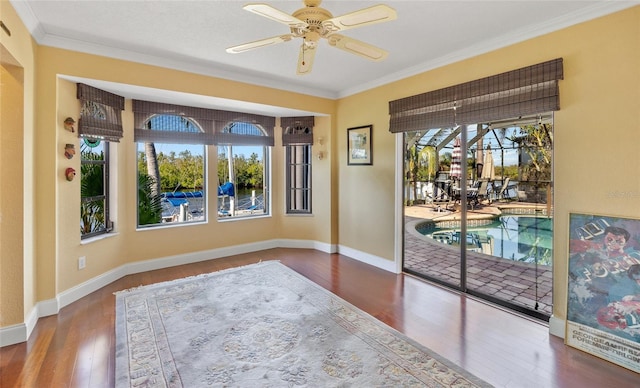 interior space with hardwood / wood-style flooring, ceiling fan, crown molding, and a wealth of natural light