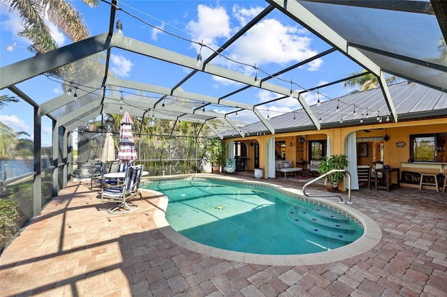 view of swimming pool with a patio area, ceiling fan, and a lanai