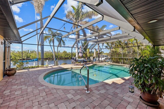 view of pool with a lanai, a water view, and a patio