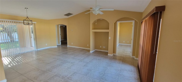 empty room featuring light tile patterned floors, ceiling fan with notable chandelier, and lofted ceiling