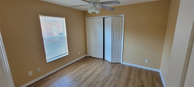 unfurnished bedroom featuring ceiling fan, light wood-type flooring, and a closet