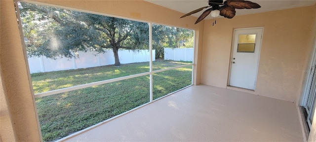 unfurnished sunroom with ceiling fan