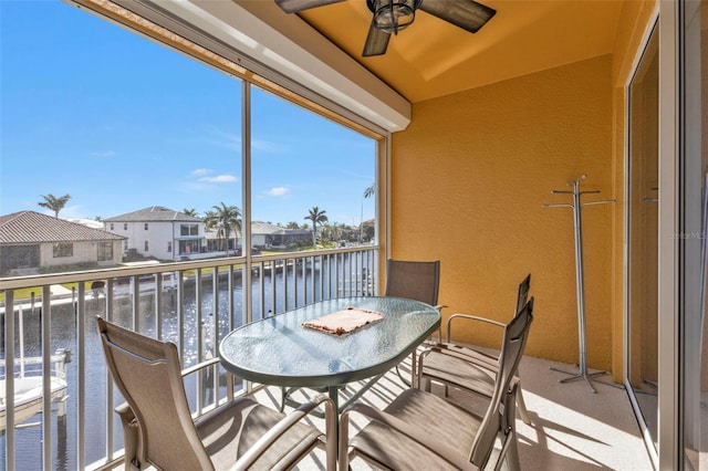 balcony featuring ceiling fan and a water view