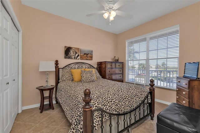 bedroom featuring ceiling fan, light tile patterned floors, and a closet