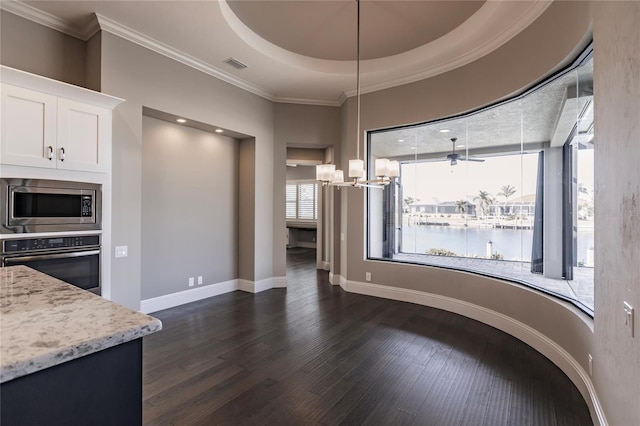 kitchen with light stone countertops, white cabinetry, dark wood-type flooring, a water view, and appliances with stainless steel finishes