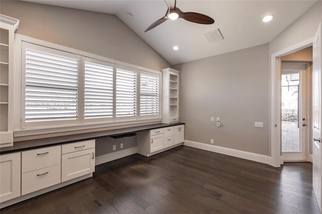 unfurnished office featuring a wealth of natural light, dark hardwood / wood-style flooring, built in desk, and lofted ceiling