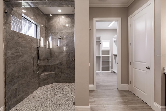 bathroom featuring crown molding and tiled shower