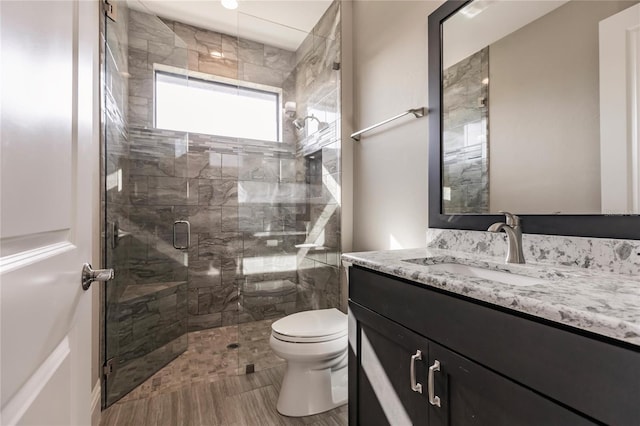 bathroom with vanity, toilet, and a shower with shower door