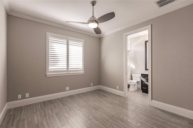 unfurnished bedroom with ceiling fan, light wood-type flooring, ornamental molding, and connected bathroom