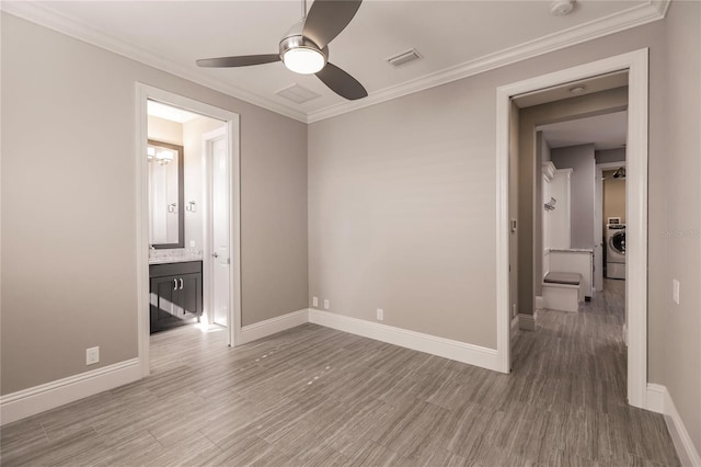 unfurnished bedroom with hardwood / wood-style floors, crown molding, ceiling fan, and washer / dryer