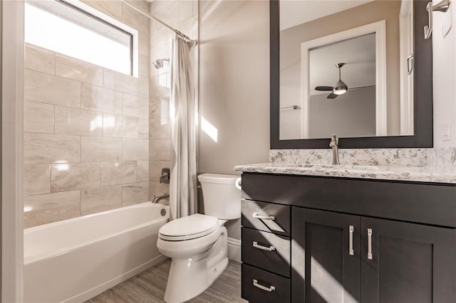 full bathroom featuring hardwood / wood-style floors, shower / bath combo, vanity, ceiling fan, and toilet