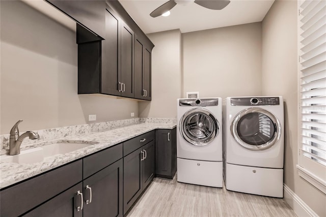 washroom with ceiling fan, sink, cabinets, washing machine and dryer, and light hardwood / wood-style flooring