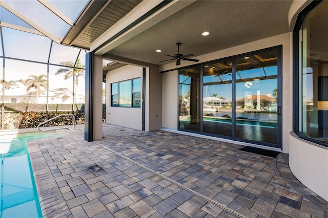 view of patio with a fenced in pool, glass enclosure, and ceiling fan