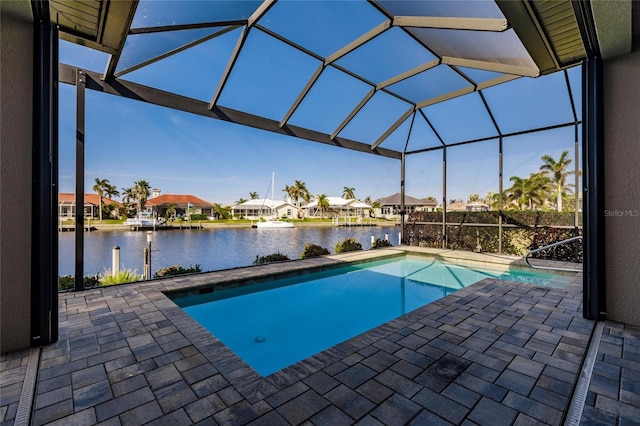 view of swimming pool with a lanai, a patio area, and a water view