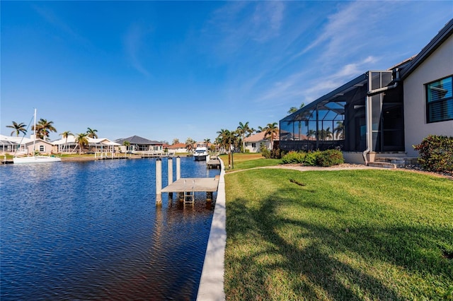 dock area featuring a water view, glass enclosure, and a lawn