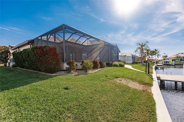 view of yard featuring glass enclosure, a dock, and a water view