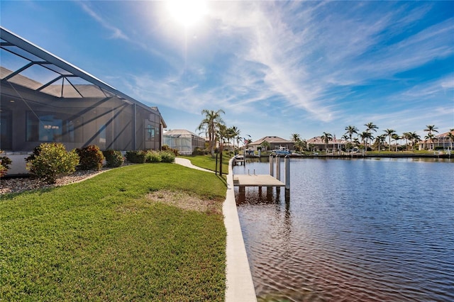 dock area with a water view, a lanai, and a lawn