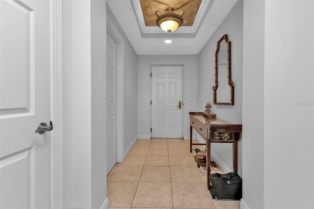 hallway featuring light tile patterned floors and a raised ceiling