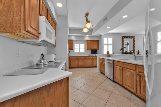 kitchen with white appliances, light tile patterned flooring, decorative light fixtures, and sink