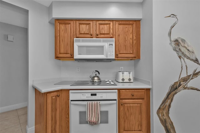 kitchen with light tile patterned flooring and white appliances