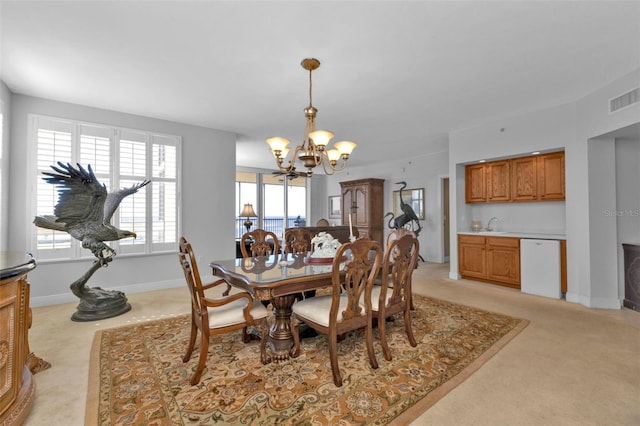 carpeted dining space with a chandelier and sink