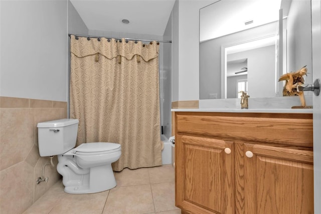 full bathroom with shower / bath combination with curtain, ceiling fan, tile walls, tile patterned flooring, and toilet