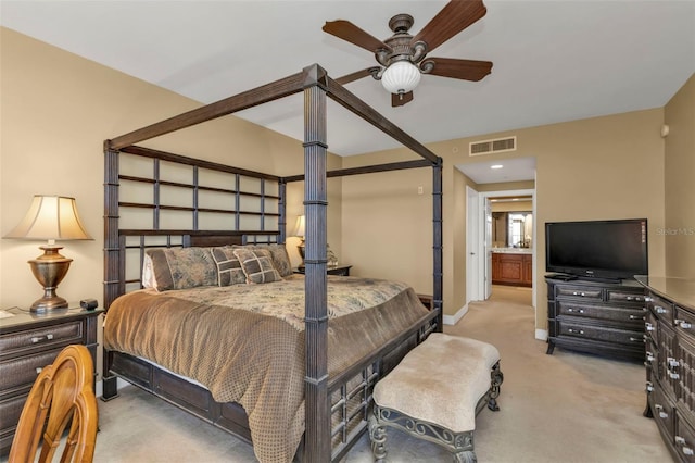 bedroom with ensuite bath, ceiling fan, and light colored carpet