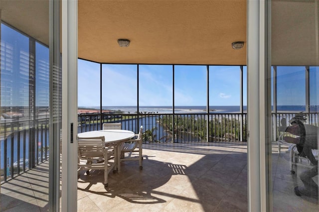 sunroom featuring a water view