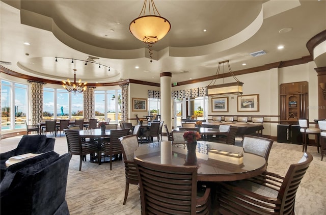 dining area featuring a raised ceiling, a chandelier, and ornamental molding