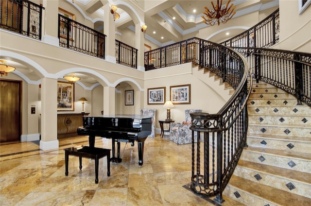 foyer entrance with beam ceiling, a towering ceiling, crown molding, and coffered ceiling