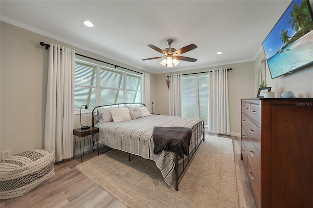 bedroom with ceiling fan, light wood-type flooring, and crown molding