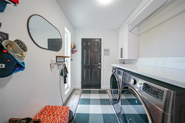 laundry area with dark hardwood / wood-style floors, cabinets, and washing machine and clothes dryer